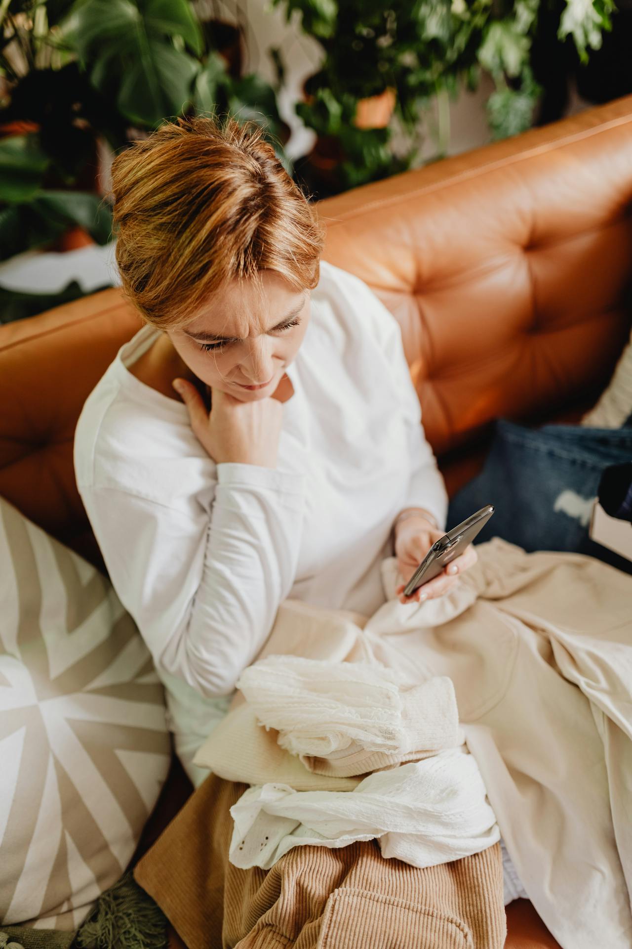 A woman at home checking an unexpected message on her phone